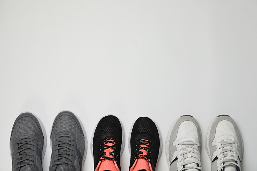 Different stylish sport shoes on white background, flat lay. Space for text