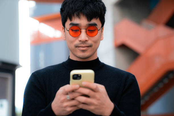 istock young asian man with red glasses typing on smartphone happy gesture 1467941275