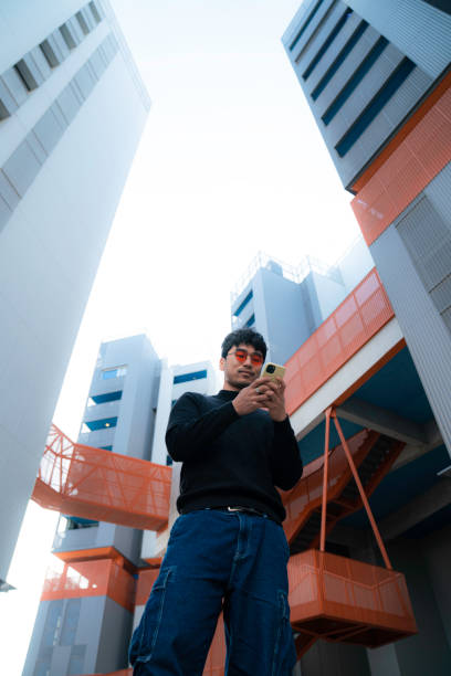 istock young asian man in cool red glasses using smartphone in futuristic modern office 1467941288