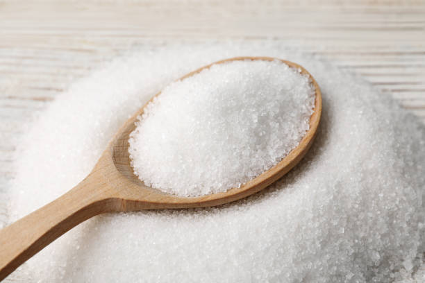 istock Spoon with granulated sugar on white wooden table, closeup 1467943104