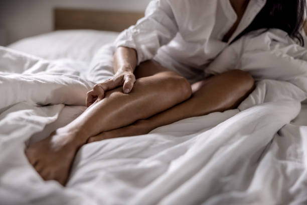 a young woman got severe cramps in her calf at night while sleeping. - kramp fotos stockfoto's en -beelden