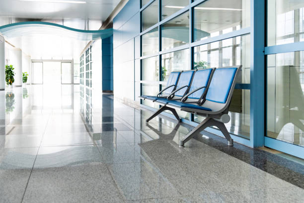 A row of empty chairs and tables against a wall in an empty room