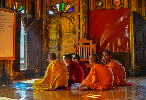 Nyaungshwe, Myanmar - Feb 8, 2017. Young Samaneras (novice monks) sitting and studying in prayer hall of Shwe Yan Pyay Monastery.