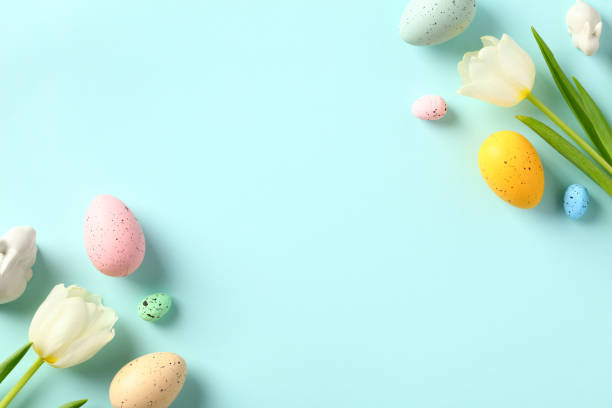 istock Happy Easter greeting card. Tulips and Easter eggs on pastel blue background. Flat lay, top view. 1467946507