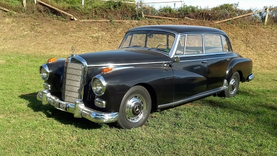 San Isidro, Argentina – October 08, 2022: Old black 1950s Mercedes Benz 300 W186 Adenauer luxury sedan in the countryside. Sunny day. Autoclasica 2022 classic car show.