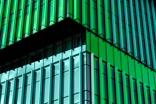 3D stimulate of high rise curve glass building and dark steel window system on blue clear sky background,Business concept of future architecture,lookup to the angle of the corner building.