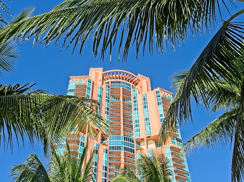 Looking up at a Miami Beach condominium tower. A common site along the coast of south Florida are the numerous high rise apartment and condominium towers housing many people with gorgeous views of the beach.