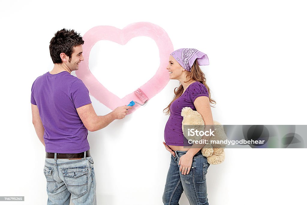 young couple painting nursery young couple painting nursery with a heart for their daughter Nursery - Bedroom Stock Photo