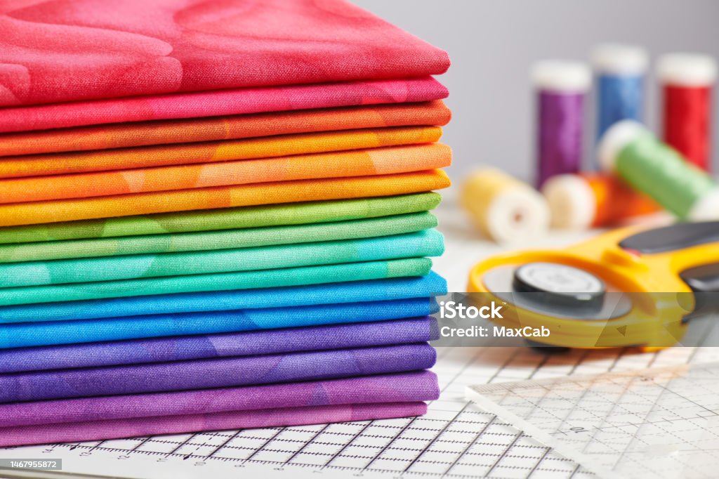 Stack of bright multicolored fabrics, accessories for sewing and quilting Textile Stock Photo