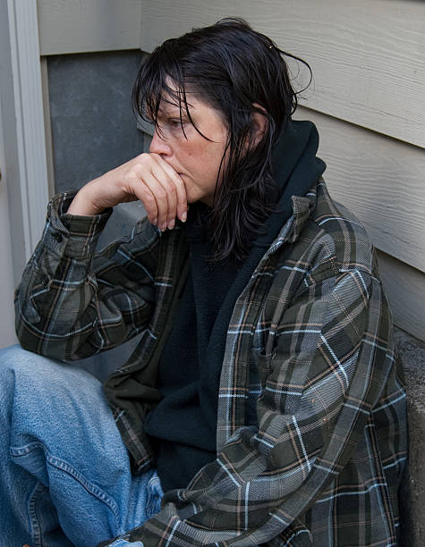 Homeless woman sitting in a stairwell.