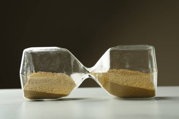 istock Hourglass with sand on white table. Menopause concept 1467956828