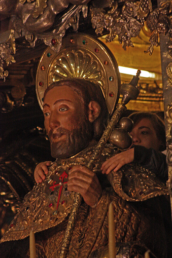 Santiago de Compostela, Spain_March 7, 2010: Apostle Santiago sculpture and woman embracing it, close-up view in Santiago de Compostela cathedral, Galicia, Spain.