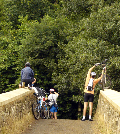 Melide, Spain- July 29, 2005: Group of cyclist pilgrims  in the 'Camino de Santiago' ,  backpacks, footpath and landscape  in summertime, Lugo province, Galicia, Spain.