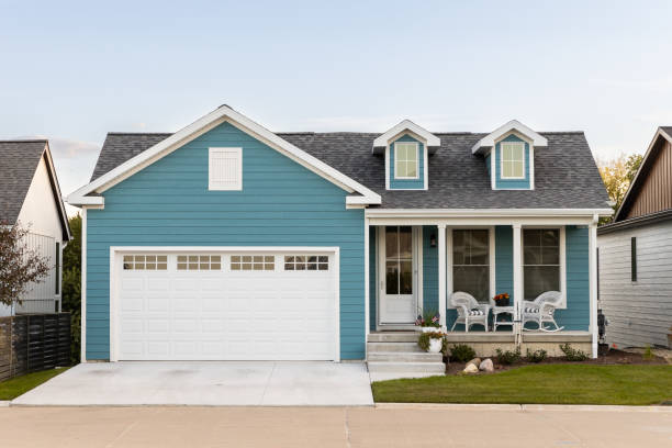 une maison de ranch bleue et blanche avec un porche couvert. - lawn residential district landscaped community photos et images de collection