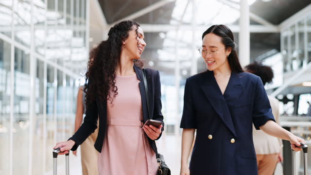 Business woman, friends and phone walking with luggage in travel for work trip together at workplace. Happy women talking or chatting on a walk to the airport for opportunity or journey with suitcase