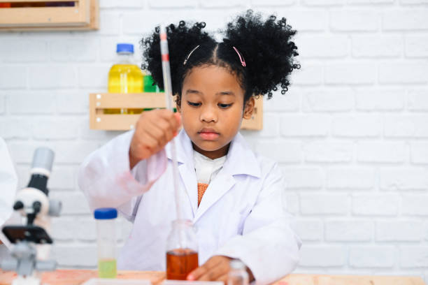 istock Child in classroom at school, Kid dressed Science lab coat. Science concept 1467961110