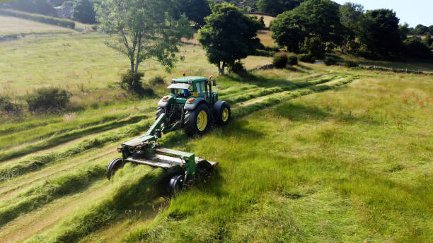 john deere 6920 tracteur et tondeuse coupant de l’herbe pour l’ensilage dans une ferme au royaume-uni - tractor farm uk agriculture photos et images de collection