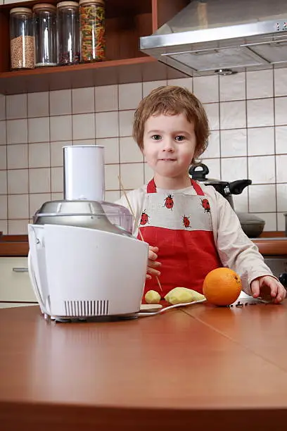 Young "cook" preparing food with food processor in the home kitchen