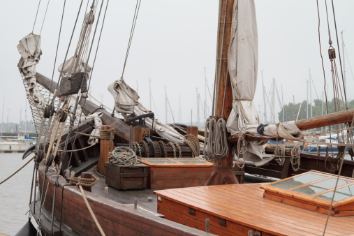 A rope on a wooden part of a sailboat and a sea in the background.