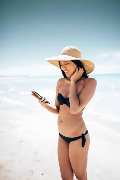 istock asian woman text messaging on the beach 1467965205