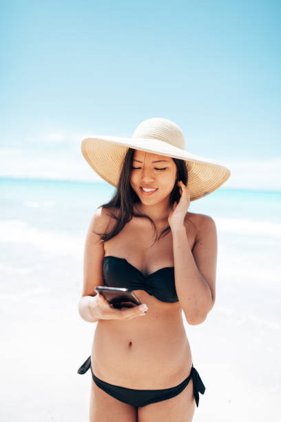 istock asian woman text messaging on the beach 1467965212