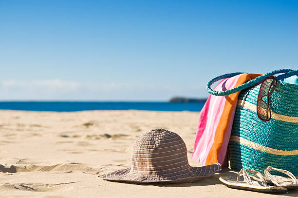 Secluded beach with white sand, a towel and hat stock photo