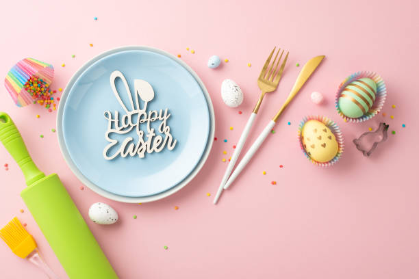 istock Easter concept. Top view photo of blue plate with inscription happy easter knife fork rolling pin brush colorful easter eggs in paper baking molds and sprinkles on isolated pastel pink background 1467968942