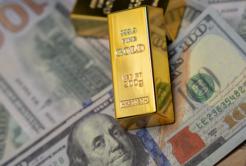 American currency Dollar and Gold ingot combinations. Close up for dollar and gold ingot stock