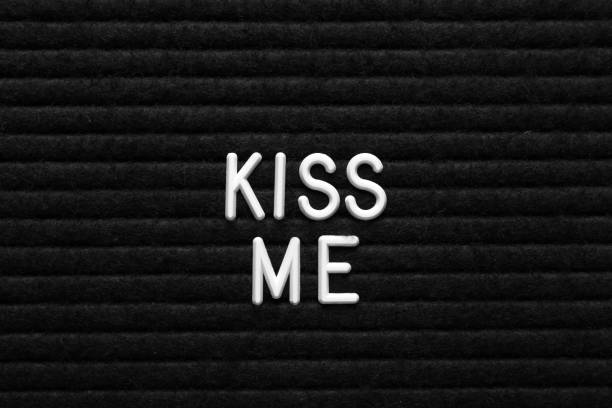 istock Phrase Kiss Me on black textured surface 1467970991