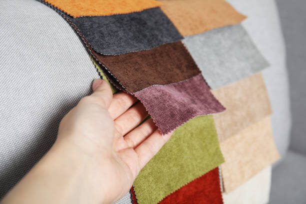 istock Woman choosing fabric among colorful samples on grey sofa, closeup 1467971096