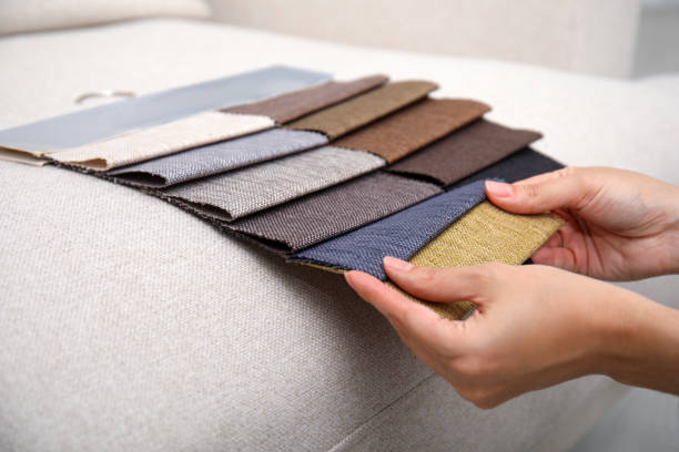 istock Woman choosing fabric among colorful samples on beige sofa, closeup 1467971137