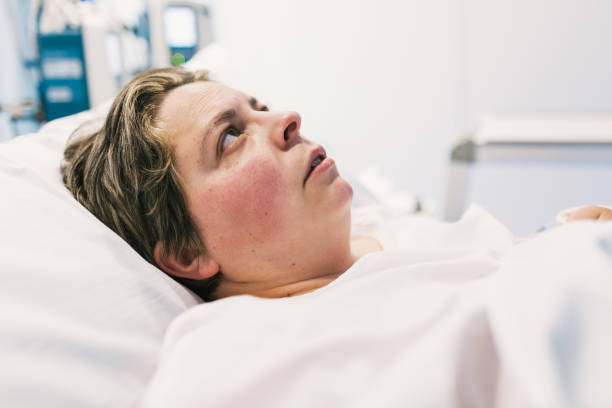 istock Woman looking up while lying on hospital bed. 1467973992
