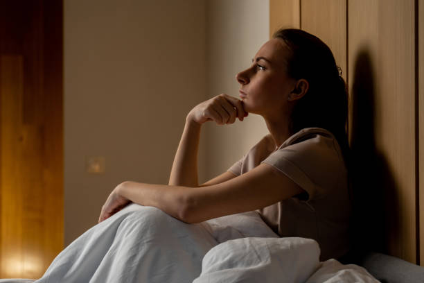 istock An unhappy woman thinking about problems, sitting on a bed in a bedroom alone, a disappointed young woman feeling lonely and sad, suffering from a bad relationship, breakup or divorce 1467974302