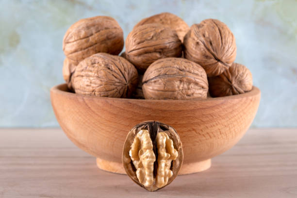 istock Whole walnuts and cracked walnuts on wooden background 1467974321