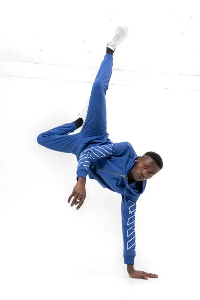 Black man of African descent wearing hooded sportswear. Athlete man doing sporty movements.