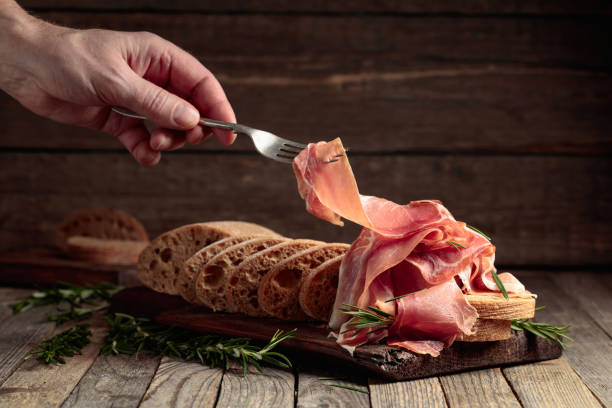 prosciutto z chlebem i rozmarynem na starym drewnianym stole. - delicatessen meat sandwich ham zdjęcia i obrazy z banku zdjęć