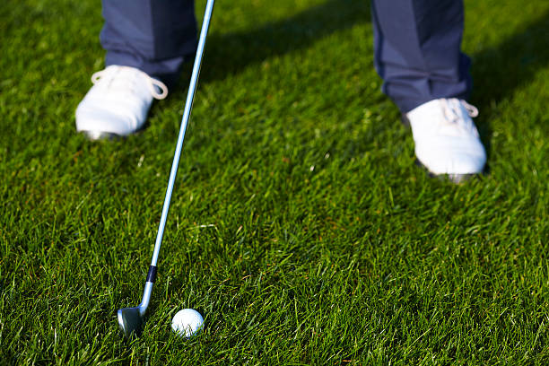 Golf ball before the swing between legs stock photo