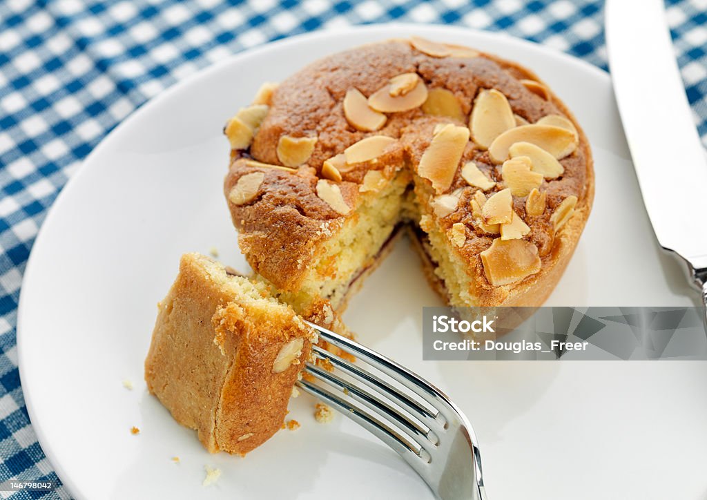 Home made Bakewell Tart Home made bakewell tart on a white plate and blue checked cloth Almond Stock Photo
