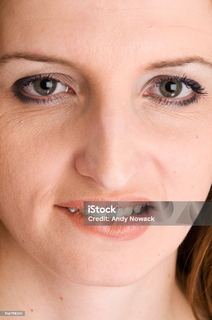 bite on the lips Portrait of a young woman biting her lip, looking at camera. Vertical composition.  20-24 Years Stock Photo