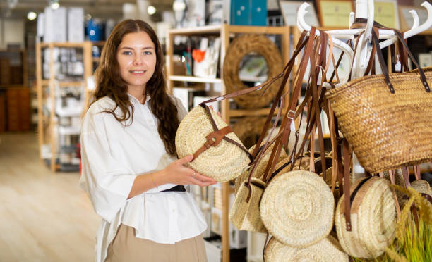 istock Young woman choosing straw bag at store 1467984972