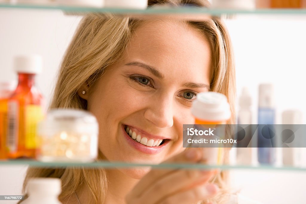 Mulher olhando no armário de banheiro - Foto de stock de Armário de Banheiro royalty-free