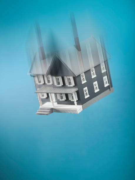 Miniature model concept house housing crash with falling residence