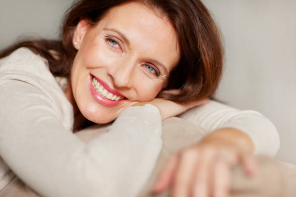 istock Smiling mature lady relaxing on couch 146798947