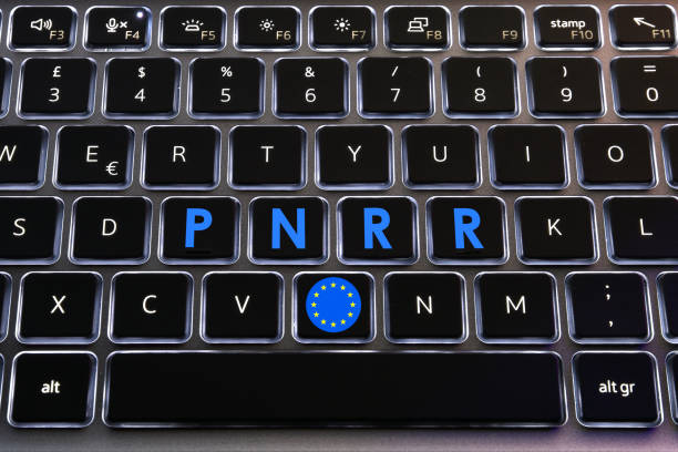 bandera de la ue y palabras 'pnrr' en los botones del teclado retroiluminado del ordenador portátil. el plan nacional de recuperación y resiliencia forma parte del programa next generation eu (ngeu). - euro symbol currency internet computer keyboard fotografías e imágenes de stock