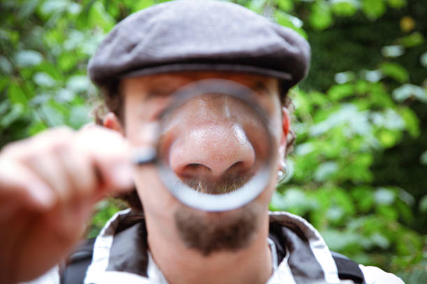 Nose man holding magnifying glass to his nose human nose stock pictures, royalty-free photos & images