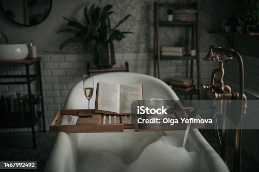 istock Luxury interior of eco style modern bathroom with oval bathtub and book on bamboo wood tray 1467992492