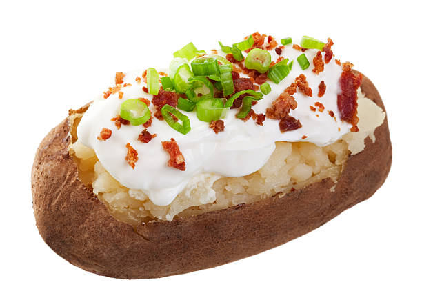 Baked Potato Loaded A baked potato loaded with sour cream, bacon bits, and chives.  Shot on white background. baked potato sour cream stock pictures, royalty-free photos & images