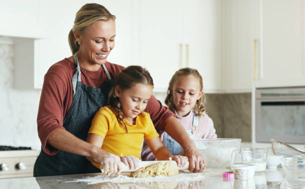 istock Mother, children and baking in the kitchen with rolling pin for teamwork helping mom mix ingredients at home. Happy mama baker and kids working together to roll cookie dough for baked creation 1467995410