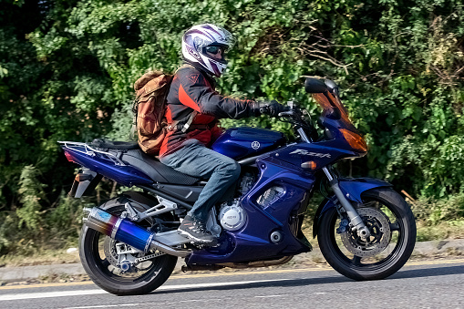 Potterspury,Northants, UK - August 14th 2022.Man riding a  2003 blue Yamaha FZS1000 Fazer motorcycle on an English country road