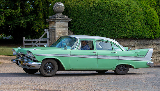 Turvey, Bedfordshire, UK - June 12th 2022. 1958 PLYMOUTH Belvedere driving through an English village